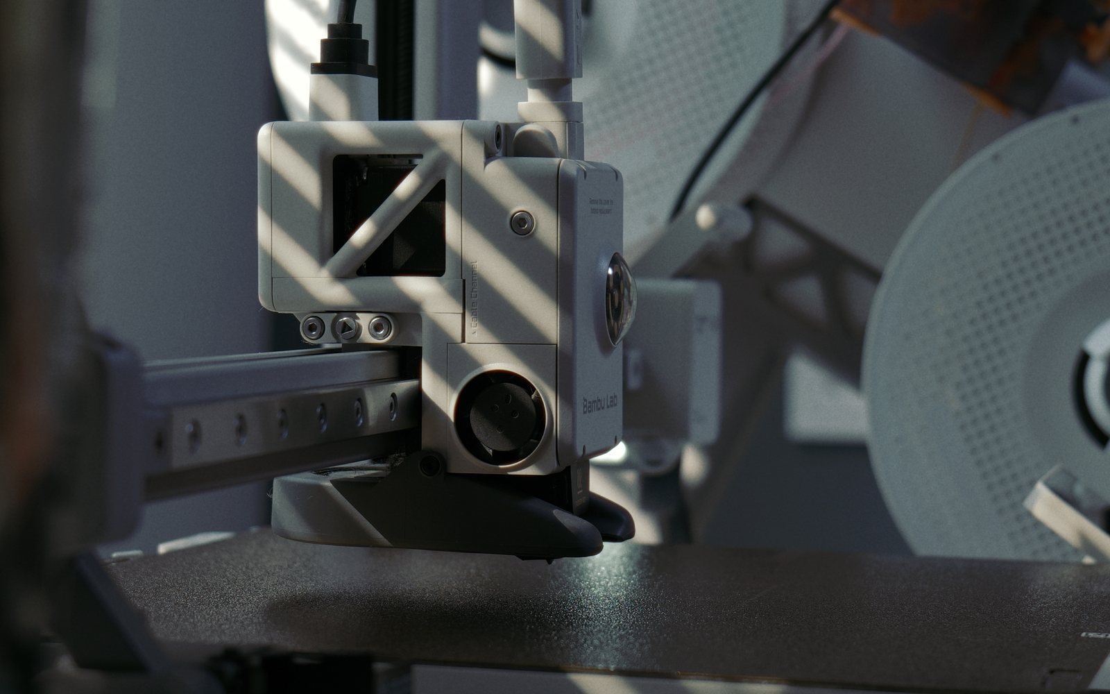 Close-up of the Bambu Lab A1's print head above the textured build plate.