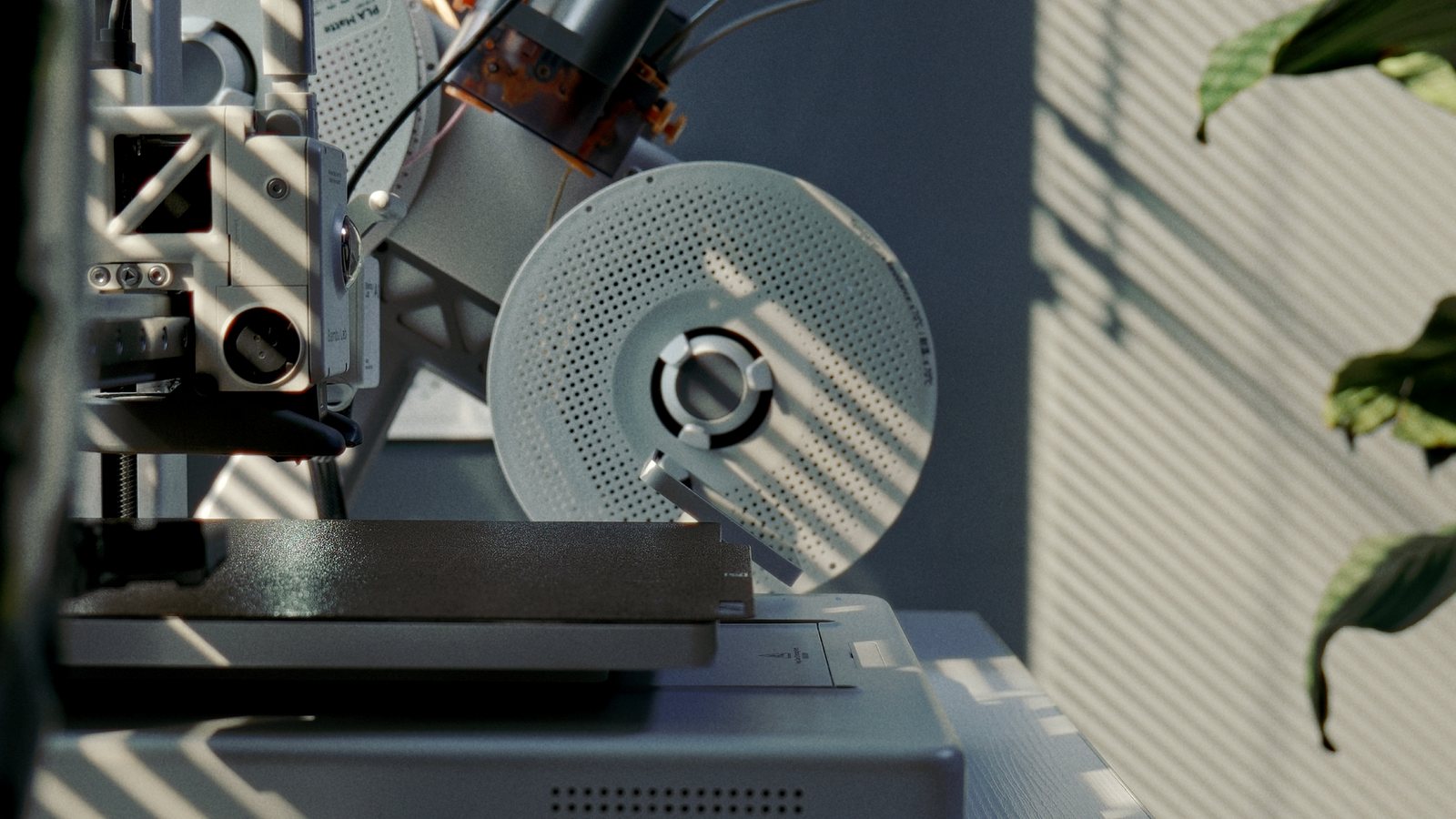 A still from the video: the A1's spool holder in striped window light.