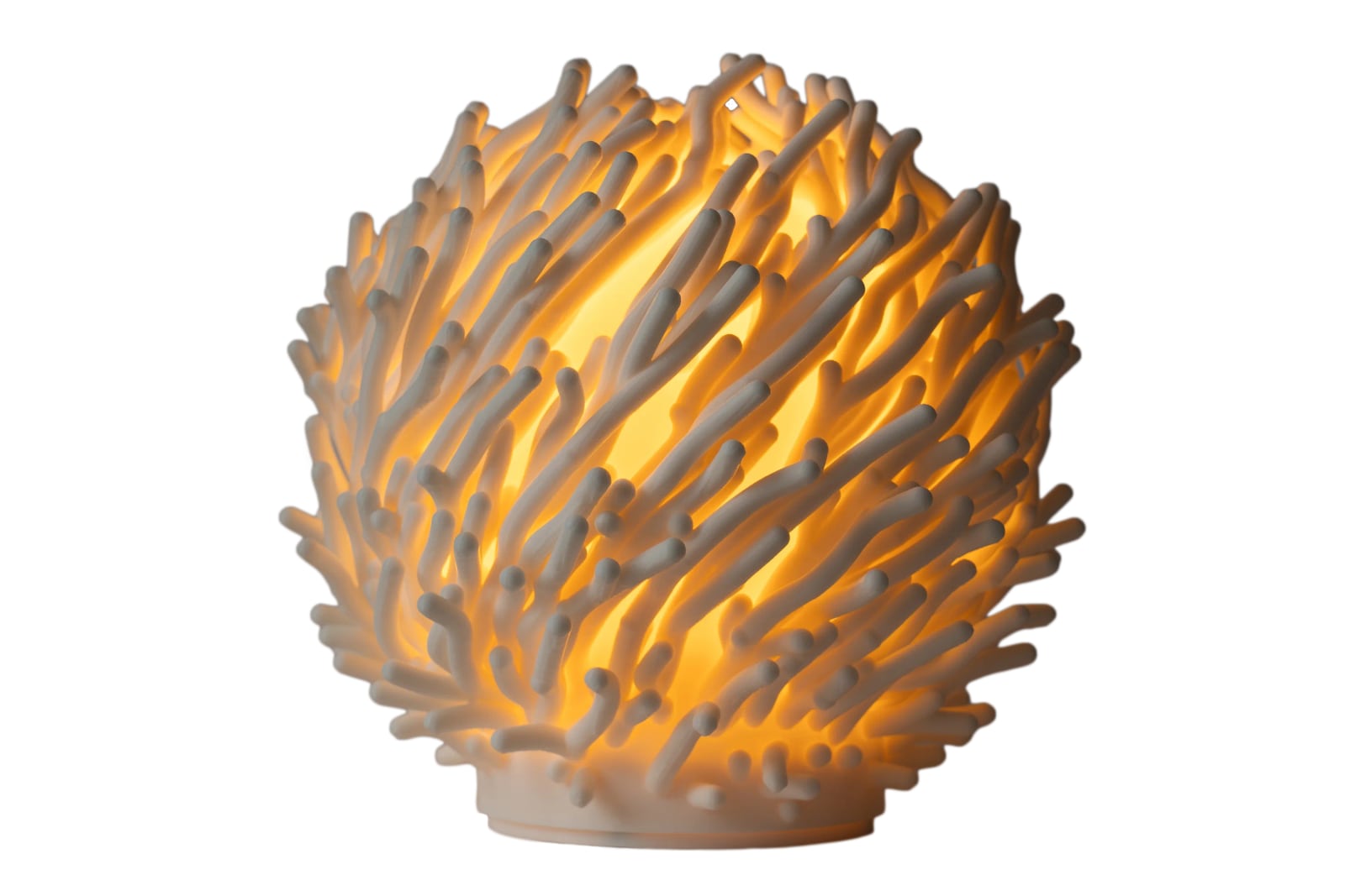 A 3D printed Coral lamp with the light on: hundreds of white branches glowing warm around the light inside.